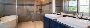 Full bathroom with large shower and two sinks with blue cabinets