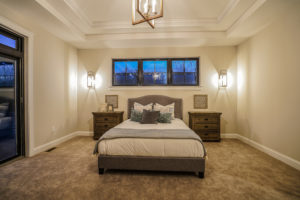 Large bedroom with a chandelier and a door leading outside