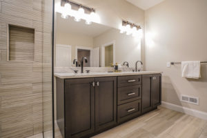 Full bathroom with two sinks and brown cabinets
