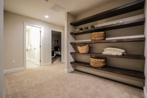 Hallway with built in wooden shelves and carpet