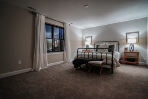 Bedroom with carpet and windows with black frames