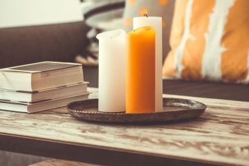 white and orange candles sitting on a wooden coffeetable