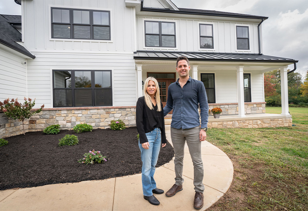 Two people standing in front of a rotelle home