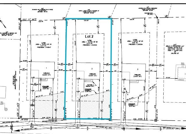 A black-and-white site plan showing multiple property lots with measurements. One lot, labeled Lot 2, is outlined in blue. Various structures, boundaries, and utility lines are marked throughout the plan.