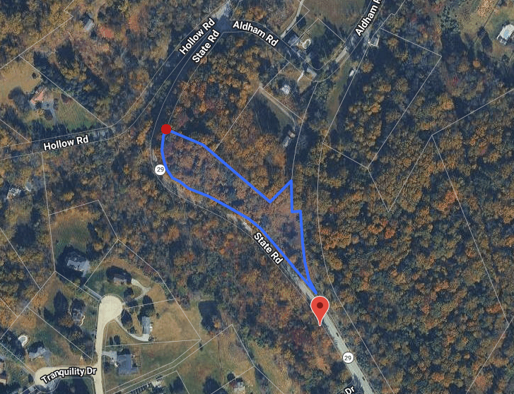A satellite map shows a forested area with houses and roads. A blue route connects two red markers, starting from Hollow Rd and winding to State Rd, with Aldham Rd visible at the top.